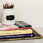 white ceramic pencil organizer on top of stack of books