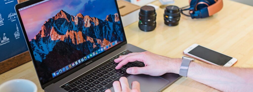 MacBook Pro turned on beside white ceramic mug