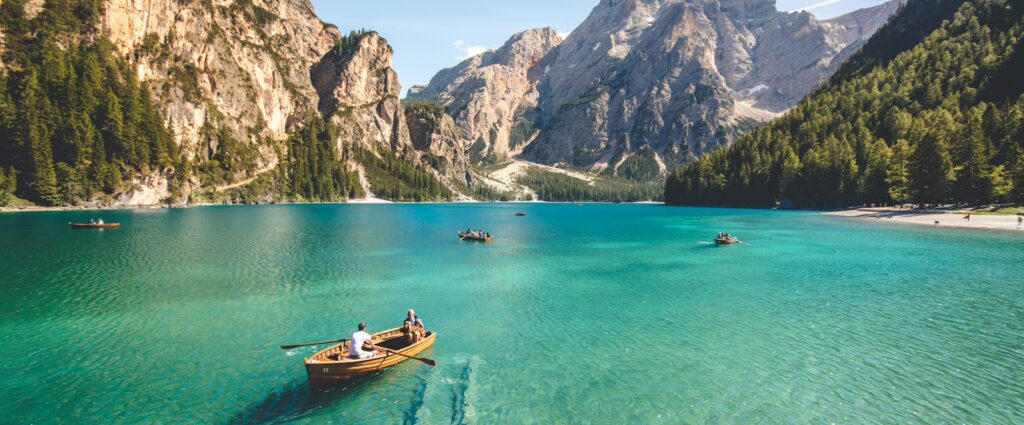 three brown wooden boat on blue lake water taken at daytime